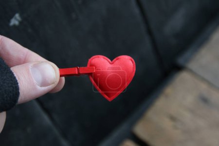 Téléchargez les photos : Saint-Valentin concept. Une main tient un cœur rouge sur un fond vintage. - en image libre de droit