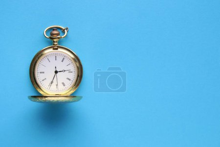Photo for Blue background. Golden retro pocket watch on a blue background. - Royalty Free Image