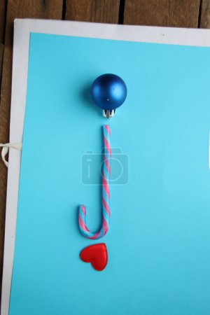 Photo for Merry Christmas creative card. Candy cane on a blue background. - Royalty Free Image