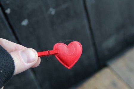 Téléchargez les photos : Saint-Valentin concept. Une main tient un cœur rouge sur un fond vintage. - en image libre de droit