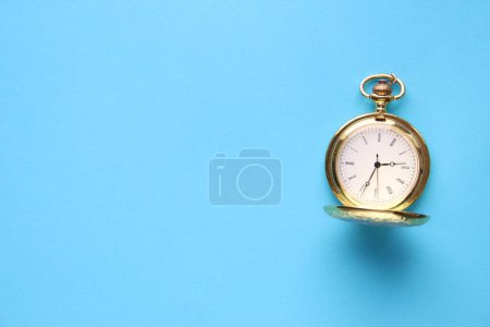 Photo for Golden retro pocket watch on a blue background. - Royalty Free Image