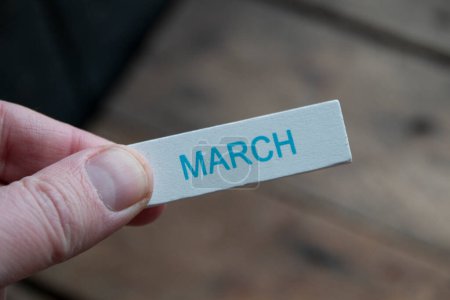 Photo for Hello March creative concept. A hand holds a sign with an inscription. - Royalty Free Image