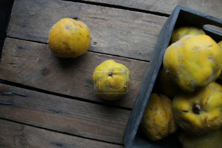 Photo for Fresh ripe organic quinces in a box on a vintage wooden table. - Royalty Free Image