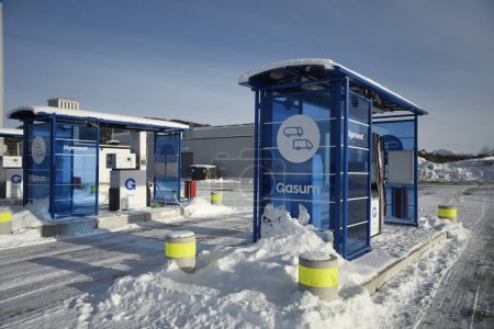Foto de Digerneset, Noruega - 10 de febrero de 2024: Gasum - Estación de servicio de gas natural para camiones. Vista de dos distribuidores diferentes bajo el techo con los alrededores. Paisaje invernal. Vista horizontal. - Imagen libre de derechos