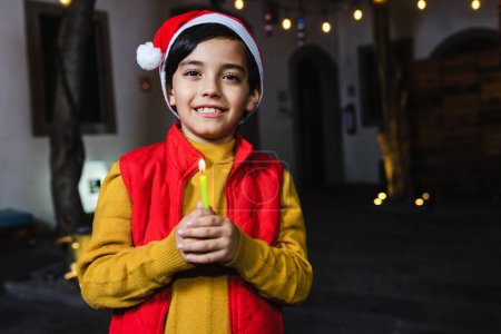 latin child boy portrait holding a candle at traditional mexican posada party for Christmas celebration in Mexico Latin America
