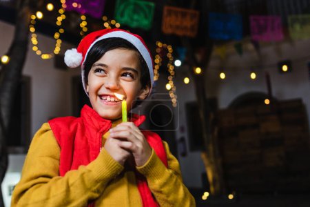 latin child boy portrait holding a candle at traditional mexican posada party for Christmas celebration in Mexico Latin America