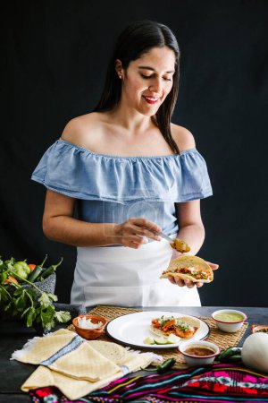 Photo for Mexican woman preparing tacos al pastor and eating mexican food in Mexico Latin America - Royalty Free Image
