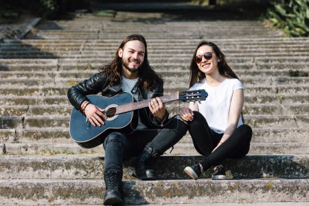 Téléchargez les photos : Jeune couple latin homme et femme dans le style rock and roll et jouer de la guitare dans la rue au Mexique Amérique latine - en image libre de droit