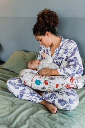 Photo for Latin mother breastfeeding her newborn baby at home in Mexico Latin America, hispanic family - Royalty Free Image