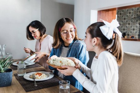 Photo for Latin family of multi generational women eating together at home in Mexico Latin America, hispanic people - Royalty Free Image