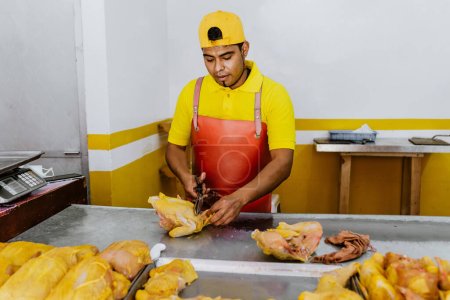 Latin man working as Poultry vendor of raw chickens being sliced by the Pollero at Chicken shop or Polleria in Mexican market in Mexico, Hispanic people working