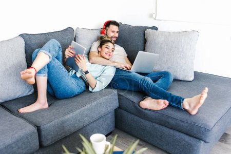 Photo for Young latin couple resting and having fun on sofa at home in Mexico, hispanic people in Latin America - Royalty Free Image