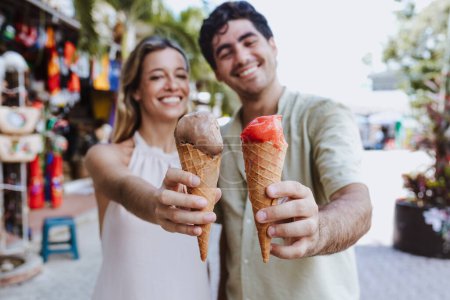 hispanic young couple eating ice cream on vacations or holidays in Mexico Latin America, Caribbean and tropical destination 