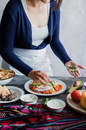 Téléchargez les photos : Femme mexicaine prépare des chilaquiles à la sauce rouge et mange de la nourriture mexicaine traditionnelle pour le petit déjeuner au Mexique Amérique latine, peuple hispanique - en image libre de droit