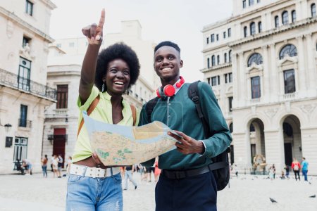 Photo for Young afro american couple tourist looking a map while on vacation during summer together in Latin America, african caribbean people on holidays - Royalty Free Image