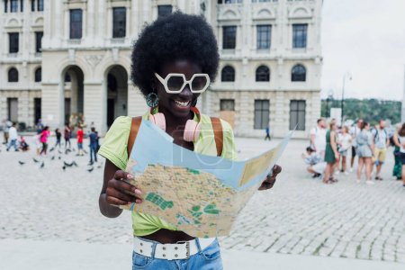 Photo for Young tourist afro american woman holding a map, young caribbean girl on holidays in Latin America - Royalty Free Image