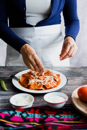 Téléchargez les photos : Mexican woman hands preparing chilaquiles with red sauce and eating traditional mexican food for breakfast in Mexico Latin America - en image libre de droit