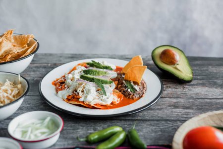 Téléchargez les photos : Chilaquiles mexicains nourriture avec sauce rouge épicée, poulet et avocat petit déjeuner traditionnel au Mexique Amérique latine - en image libre de droit