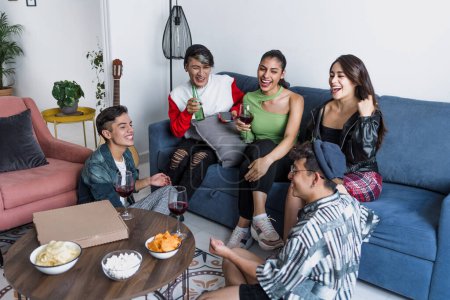 Photo for Group of latin LGBT friends eating pizza, drinks and having fun at home in Mexico, Hispanic homosexual and lgbtq community in Latin America in party - Royalty Free Image