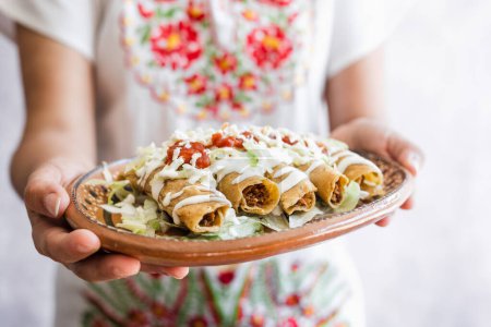 Photo for Mexican tacos dorados called flautas with chicken, traditional fried food in Mexico Latin America - Royalty Free Image