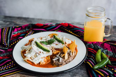 Photo for Mexican chilaquiles food with spicy red sauce, chicken and avocado traditional breakfast in Mexico Latin America - Royalty Free Image