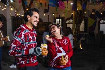 Mexican young couple or friends having fun in posada celebration for Christmas in Mexico Latin America
