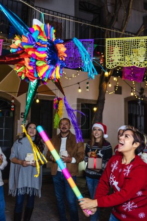 Hispanische Familie bricht eine Pinata bei der traditionellen mexikanischen Posada-Feier zu Weihnachten in Mexiko Lateinamerika