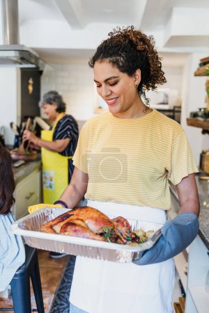Photo for Latin woman cooking turkey meat for Christmas dinner at home in Mexico Latin America, hispanic family preparing food in holidays - Royalty Free Image