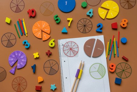 Fractions, rulers, pencils, notepad on brown background. Set of supplies for mathematics and for school.  Back to school, fun education concept