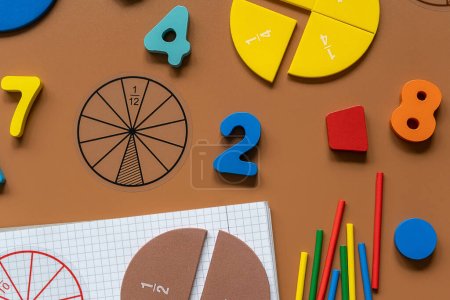 Fractions, rulers, pencils, notepad on brown background. Set of supplies for mathematics and for school.  Back to school, fun education concept