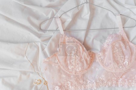 Photo for Gentle pink lace bra on the bed. Women tender lingerie, underwear. Top view, close up. Flat lay, beauty blog or social media minimal concept. Present for Valentines, Womens day - Royalty Free Image