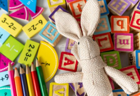 Téléchargez les photos : Bunny fermer avec des crayons, des fractions, des blocs sur la table. activités pour les enfants. préscolaire, jardin d'enfants - en image libre de droit