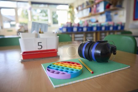 Ohrenschützer oder Kopfhörer und Fidget Toy, um Kindern mit ASS oder Autismus auf dem Tisch im Klassenzimmer zu helfen