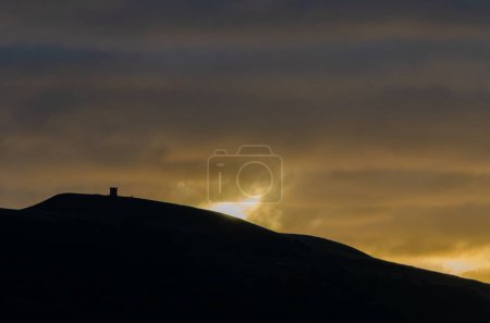 Foto de Otoño amanecer en Rivington Pike con colina en silueta y sol iluminación nubes naranja y amarillo - Imagen libre de derechos