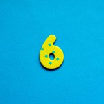 number six on blue paper background
