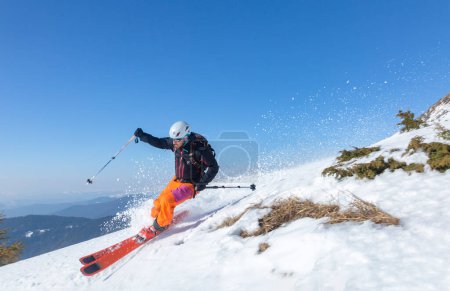 Photo for Marmaros, The Carpathians, UKRAINE - March 15 2021: Skier skiing downhill during sunny day in high mountains - Royalty Free Image