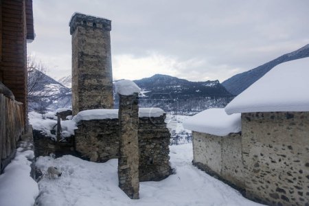 Téléchargez les photos : Old ruins of the Svan city of Mestia surrounded by misty winter mountains, Svaneti, Caucasus - en image libre de droit