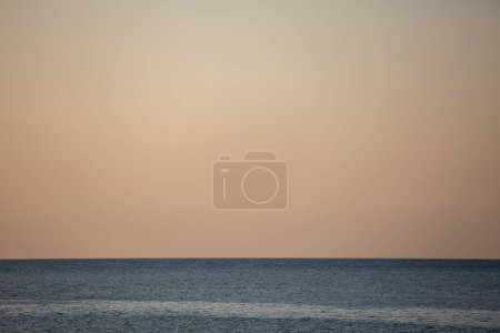 Photo for The blue line of calm sea water and yellow evening sky - Royalty Free Image