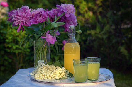 Photo for A Bottle and Glasses Of Homemade Lemonade Made From Elderberry Syrup on Table - Royalty Free Image