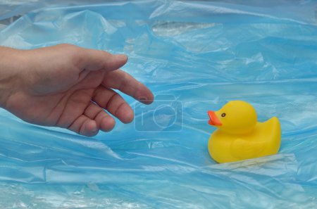 Photo for Concept Pollution Plastic In Sea with Yellow Rubber Duck Toy and Man Hand - Royalty Free Image