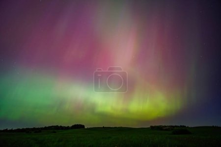 Téléchargez les photos : L'aurore boréale est un phénomène atmosphérique spectaculaire qui ressemble à un arc-en-ciel dans le ciel, avec des lumières vertes vibrantes dansant à travers le paysage naturel - en image libre de droit