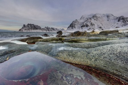 Foto de Los ojos del dragón, en la hermosa y sorprendente playa de Uttakleiv. Islas Lofoten en Noruega, Paisaje invernal. Destino turístico. - Imagen libre de derechos
