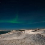 Aurora Borealis or Northern lights the amazing wonder of nature in the dramatic skies of Iceland. Night landscape with the green light and the white snow of winter