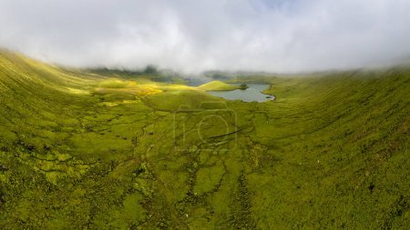 Foto de Natural landscape, panoramic view. Beautiful lagoon in the volcanic Caldeirao crater an at Corvo island, Azores, Portugal. Nature and science in this amasing tavel destination. - Imagen libre de derechos