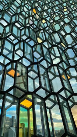 Foto de Glass wall of Harpa concert hall, Reykjavik, Iceland. Colorful glass windows with abstract geometry. Modern art at amazing travel destination and tourist attraction in the Nordic country. - Imagen libre de derechos