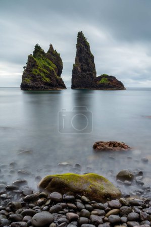 Photo for Alagoa Bay, amazing beach on Flores Island in Azores, Portugal. Seascape or costal landscape in a travel destination and tourist attraction, of rare natural beauty. Black sand beach and round stones. - Royalty Free Image