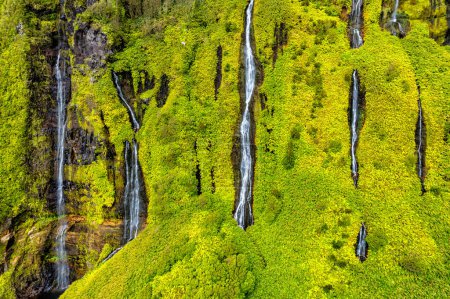 Azores scenic aerial drone landscape, Flores island. Iconic lagoon with several waterfalls on a single rockface, flowing into lake Alagoinha. Best travel destination in Portugal.