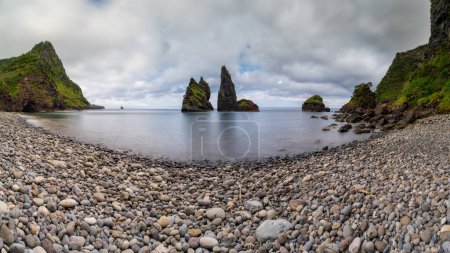 Photo for Alagoa Bay, amazing beach on Flores Island in Azores, Portugal. Seascape or costal landscape in a travel destination and tourist attraction, of rare natural beauty. Black sand beach and round stones. - Royalty Free Image