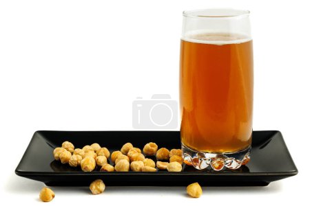 Photo for Beer with hazelnuts on a black plate. - Royalty Free Image