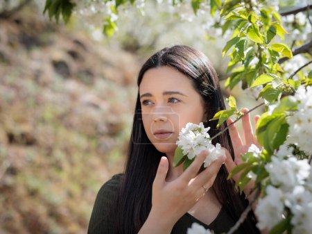 Téléchargez les photos : Jeune femme tient des fleurs de cerisier. - en image libre de droit